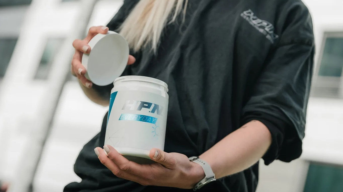 Frau öffnet eine Dose H.P.N Everyday und hält den Deckel in der Hand.